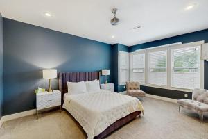 a bedroom with blue walls and a bed and a chair at Wander Bentonville in Bentonville