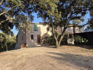 a white house with a tree and a bench at Clos de Valamade in Cannes-et-Clairan
