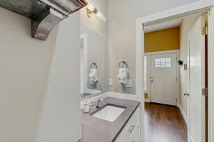 a white bathroom with a sink and a mirror at Wander Bentonville in Bentonville +9 photos
