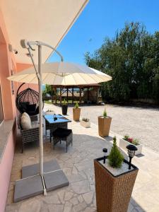 a patio with a table and an umbrella at Casa Mia in Višići