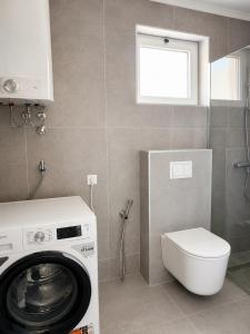 a bathroom with a washing machine and a toilet at Casa Mia in Višići +17 photos