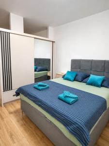 a bedroom with a large bed with blue pillows on it at Casa Mia in Višići