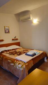 a bedroom with a large bed with a blanket at Apartman Blue Cross in Međugorje