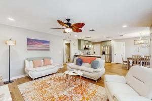 a living room with two white couches and a table at Emerald Escape in Corpus Christi