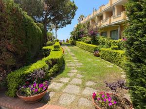 a garden with flowers and bushes and a building at Belvedere Blu b&b & beach in Belvedere Marittimo