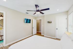 a bedroom with white walls and a ceiling fan at Emerald Escape in Corpus Christi