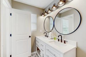 a bathroom with a sink and a large mirror at Emerald Escape in Corpus Christi +10 photos