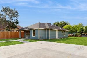 a small blue house with a fence in a yard at Emerald Escape in Corpus Christi