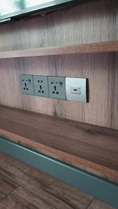 a row of light switches on a wooden wall at Arcadia Family Vacation House in Çilǝgir