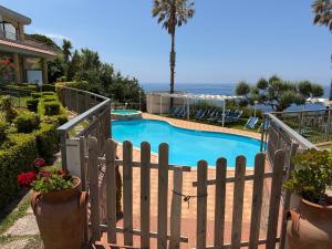 a swimming pool with a wooden fence and flowers at Belvedere Blu b&b & beach in Belvedere Marittimo +11 photos