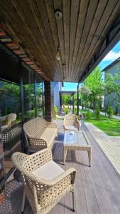 a patio with wicker chairs and tables on a deck at Arcadia Family Vacation House in Çilǝgir