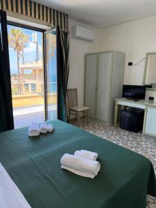 a room with a green table with towels on it at Belvedere Blu b&b & beach in Belvedere Marittimo