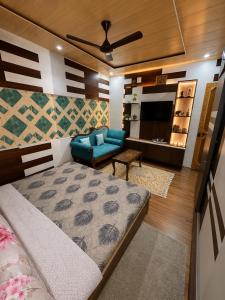 a bedroom with a bed and a couch and a tv at Sultan Homestay in Srinagar