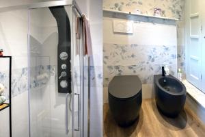 a bathroom with a shower and a black toilet at Ramoscello in Altare