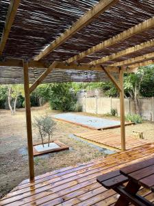 a wooden pergola with a picnic table in a yard at CAEN ça repose ! in Caen