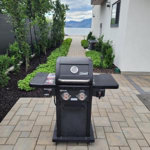 a grill sitting on a table in a backyard at Lakeview Main Floor Suite 104 in Peachland