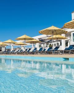a swimming pool with chairs and umbrellas at Sea Dreamer in Nags Head +28 photos