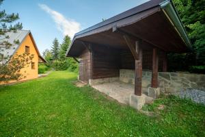 a wooden building with a roof on a grass field at Horská chata ERIK in Levoča
