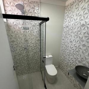 a bathroom with a shower with a toilet and a sink at Loft Lux SM Chapecó com excelente localização! in Chapecó
