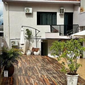 an outdoor patio with potted plants and an umbrella at Loft Lux SM Chapecó com excelente localização! in Chapecó