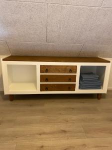 a white cabinet with drawers underneath a bed at Uggerhøjvej Gårdhygge in Hjørring