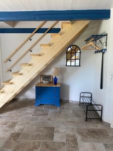 a room with a staircase with a blue dresser and a table at Uggerhøjvej Gårdhygge in Hjørring +5 photos