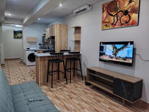 a living room with a couch and a tv on a wall at Departamento Grupo in Lima