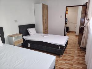 a room with two beds and a mirror at Departamento Grupo in Lima