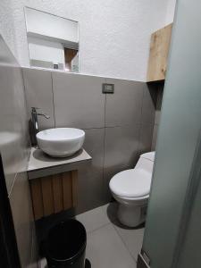 a bathroom with a white toilet and a sink at Departamento Grupo in Lima +2 photos