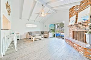 a living room with a brick fireplace and a couch at Balboa Duplex in Newport Beach