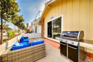 a outdoor patio with a grill and blue chairs at Balboa Duplex in Newport Beach +17 photos
