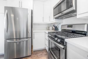 a kitchen with a stainless steel stove and refrigerator at Aloha Amigos Surf Getaway in San Clemente