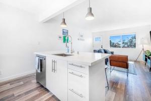 a kitchen with white cabinets and a sink at Aloha Amigos Surf Getaway in San Clemente +7 photos