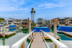 a dock with boats in a marina with houses at Balboa Blue Lagoon in Newport Beach