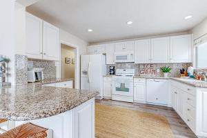 a kitchen with white cabinets and a large island at Balboa Blue Lagoon in Newport Beach