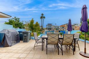 a patio with a table and chairs and a grill at Balboa Blue Lagoon in Newport Beach