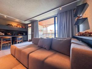 a living room with a couch and a dining room at NAAY - Nature 106 in Pôrto de Pedras