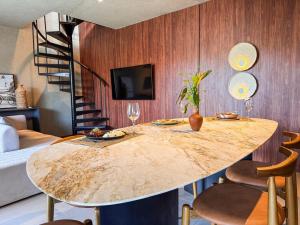 a dining room with a large marble table and chairs at NAAY - Nature 106 in Pôrto de Pedras