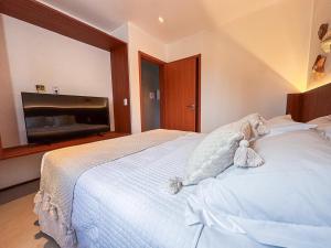 a bedroom with a white bed with teddy bears on it at NAAY - Nature 106 in Pôrto de Pedras +5 photos