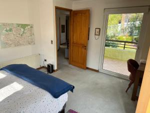 a bedroom with a bed and a sliding glass door at Casa Super Vista a los Andes in Santiago