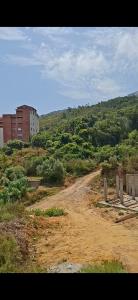 a dirt road with a building on the side of a hill at اولاد بونار in Jijel