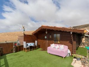a log cabin with a table and chairs in the yard at La Maxada Luz Maria in El Cotillo