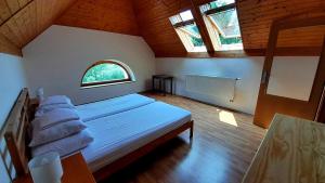 a bedroom with a large white bed with a window at Penzion Skřítkův grunt in Struhařov