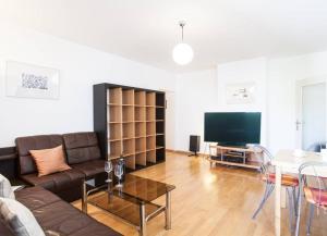 a living room with a couch and a table and a television at Suite mit Blick auf den Grünberg - 65 m2 in Gmunden