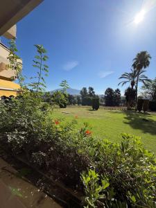 a yard with a field of grass and flowers at Atalaya Green Nest in Estepona