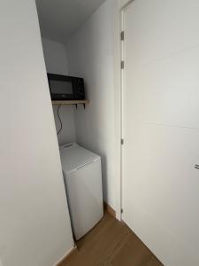 a small white room with a microwave on a shelf at Atalaya Green Nest in Estepona