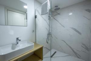 a bathroom with a sink and a glass shower at Opera City Center Hotel in Tbilisi City