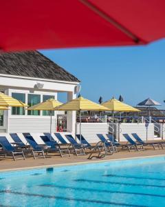 a group of chairs and umbrellas next to a swimming pool at Seawatch 5 in Nags Head