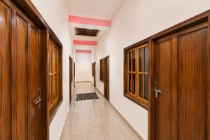 an empty corridor with wooden doors and a hallway with a hallwayngth at SPOT ON ROYAL KING HOTEL in Lucknow