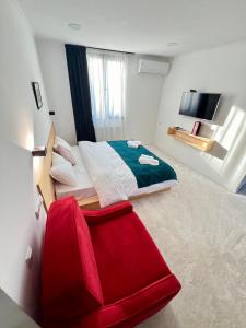 a bedroom with a red chair and a bed at Opera City Center Hotel in Tbilisi City
